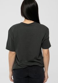 Dark gray cotton t-shirt with short sleeves and a relaxed fit, featuring a crew neckline and minimal stitching details on the back.