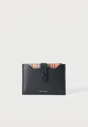 Czarny skórzany portfel na karty z paskiem na guzik oraz kolorowym, paskowanym wewnętrznym brzegiem, oznakowany złotym napisem "Paul Smith".