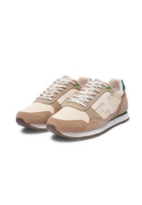 Beige- und braune Sneakers aus Wildleder und Canvas, mit weißen Schnürsenkeln, grünen Akzenten, strukturiertem Außensohlenprofil und einem Logo an der Seite.