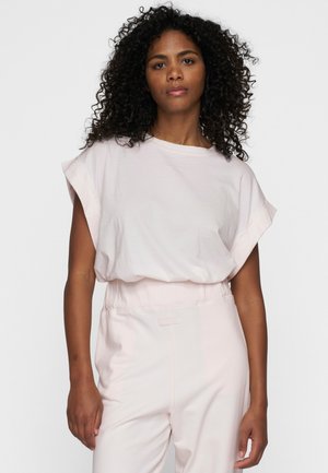 Camicia corta rosa chiaro con maniche corte, scollatura ampia e vestibilità rilassata, abbinata a pantaloni rosa chiaro coordinati. Tessuto morbido, design minimalista.