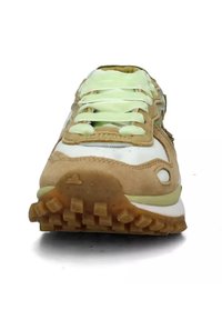 Sneaker in suede tan e mesh bianco con lacci verdi. Presenta un colletto imbottito e suola in gomma testurizzata con trazione prominente.