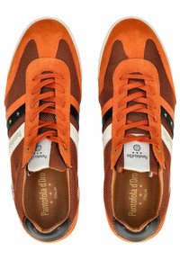 Oranžové semišové a síťované sportovní boty s černobílými pruhy, kulatou špičkou, plochými tkaničkami a logem na jazyku. Texturovaná gumová podrážka.