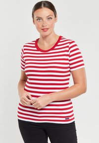 Rood-wit gestreepte t-shirt met een geribbelde structuur en ronde halslijn. Beschikt over korte mouwen en een klein logo aan de onderkant.