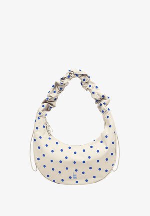 Beigefarbene, halbmondförmige Tasche mit blauen Punkten, gerafftem Henkel, Reißverschluss und dem Text „"GOT BAG"“ vorne in der Mitte.