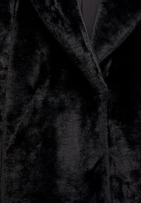 Czarny płaszcz z futra syntetycznego z miękką, puszystą teksturą, z kołnierzem typu szal i eleganckim, smukłym krojem. Brak widocznych zapięć.