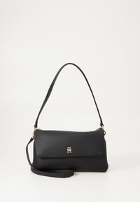 Bolso negro de hombro en material suave, con tapa plegable y acento de logo dorado. Correa ajustable para mayor versatilidad.