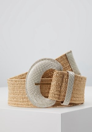 Breiter gewebter hellbrauner Gürtel mit großer strukturierter cremeweißer Schnalle und passender Schlaufe, auf weißer Fläche vor schlichten Hintergrund präsentiert.