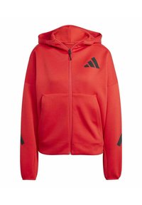 Rote Kapuzenjacke mit Reißverschluss, aus strukturiertem Stoff. Verfügt über eine frontale Tasche, schwarzes Logo auf der Brust und schwarze Akzente an den Ärmeln. Kapuzendesign.