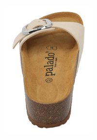 Beige leren slide sandalen met een zilverkleurige metalen gesp, een getextureerde binnenzool en een bruine kurken basis voor extra comfort en ondersteuning.