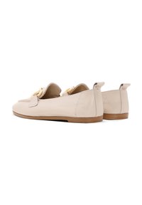 Mocassini in pelle beige con una leggera lucentezza, dotati di punta arrotondata, dettagli in hardware dorato e suola piatta in legno.