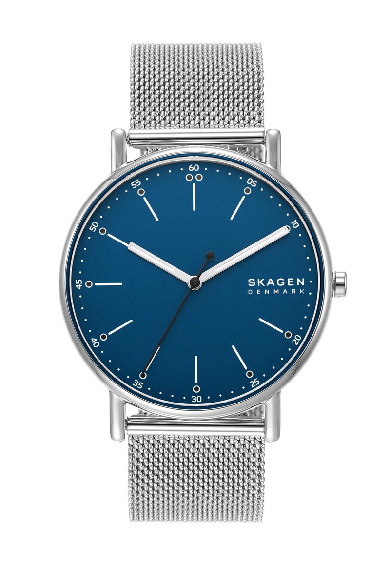 Okrągły zegarek Skagen z niebieską tarczą, srebrnymi indeksami godzinowymi i stalową siatkowymi paskiem. Minimalistyczny design, brak oznaczeń numerycznych, eleganckie wykończenie.