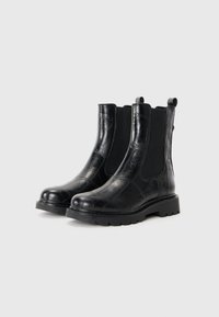 Bottines Chelsea en cuir texturé noir, avec des panneaux élastiques sur les côtés, des languettes de tirage et des semelles robustes pour une bonne adhérence et stabilité.