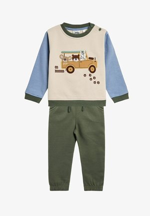 Compleu din bumbac format din două piese, cu un top bej și broderie cu animale, mâneci albastre și pantaloni verzi. Talie elastică cu detaliu de șnur.