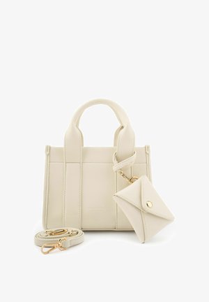 Crèmekleurige leren handtas met twee handvatten, een afneembare riem en een kleine bijpassende enveloppenportemonnee bevestigd met een gouden sluiting.