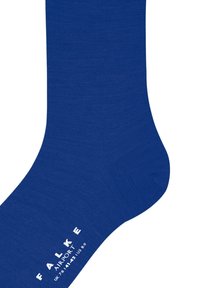 Kék zokni sima anyagból. A talprészen fehér logó és méretadatok találhatók. Klasszikus, egyszínű kialakítás.