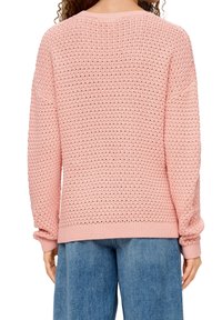 Pull en tricot rose clair avec un motif de trame lâche, ourlet et poignets côtelés, et épaules tombantes pour une coupe décontractée.