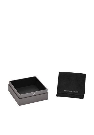 Scatola regalo quadrata grigia con interno nero, caratterizzata da un logo discreto sul fronte. Accanto c'è un sacchetto in suede nero con branding in rilievo.