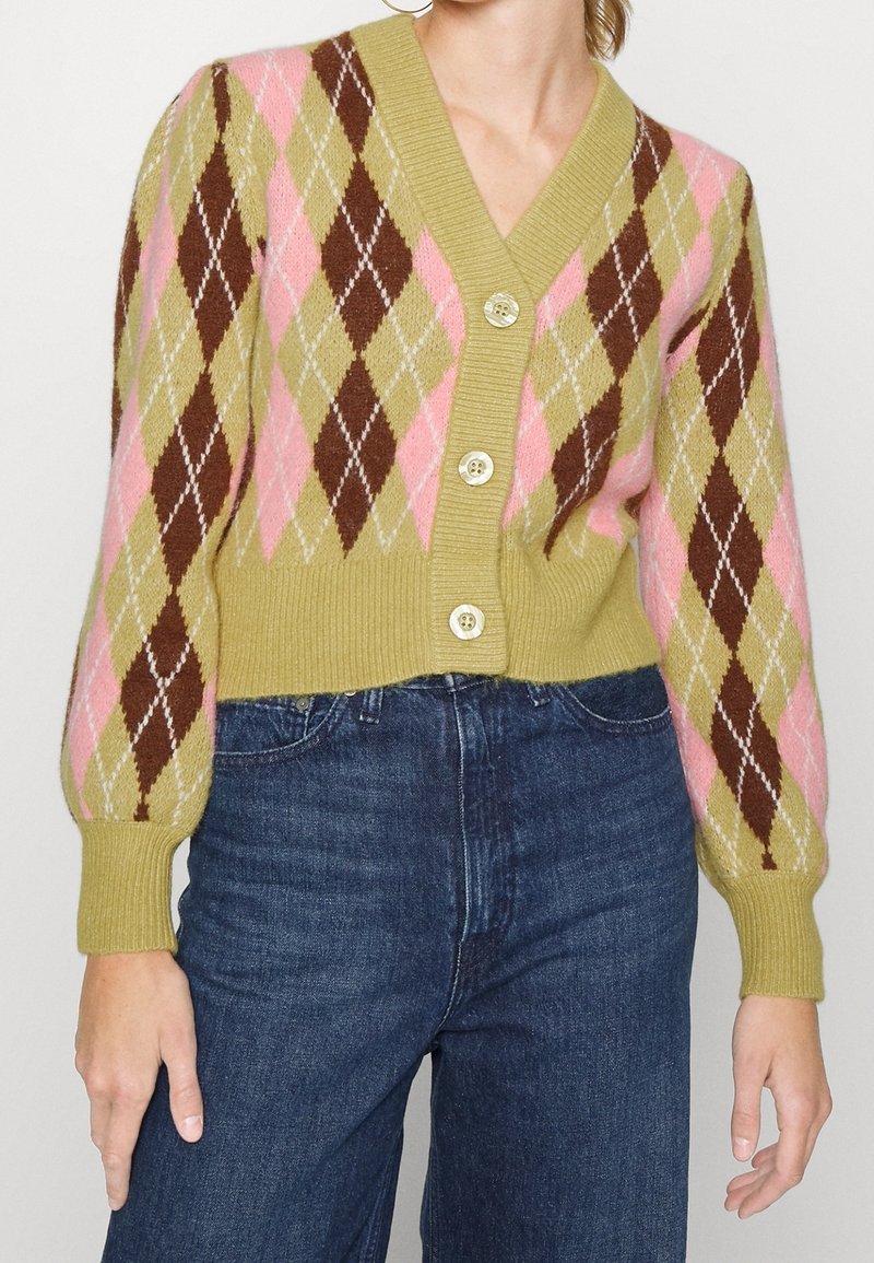 Grön cardigan med argyle-mönster i rosa, brunt och beige. Har V-ringning, ribbad mudd och fyra knappar framtill.