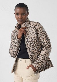 Chaqueta acolchada con estampado de leopardo en tonos beige y marrón, que presenta un cuello alto, cierre de cremallera y un parche con el logo en la manga.
