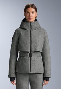 Sivý kabát v rybárskom vzore s vysok�ým golierom, zipsom vpredu, širokými manžetami a priliehavým opaskom v oblasti pása. Materiál sa zdá byť štruktúrovaný a textúrovaný.