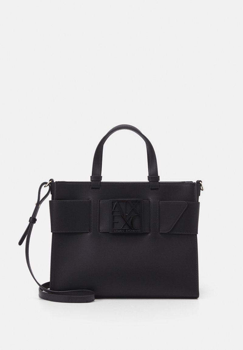 Black synthetic handbag with structured shape, dual top handles, an adjustable shoulder strap, and a prominent embossed logo on the front.
