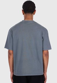Grå bomulds t-shirt med korte ærmer og en afslappet pasform. Bagsiden har et enkelt design uden synlig mærkning eller mønstre.
