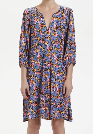 Robe florale avec un fond bleu vif orné de fleurs roses, jaunes et oranges. Décolleté en V, manches trois-quarts, longueur genou.