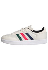 Białe sportowe buty z teksturowaną cholewką, zdobione zielonymi, różowymi, granatowymi i białymi paskami. Gumowa podeszwa z wzorowanym gripem. Klasyczny design sznurówek.