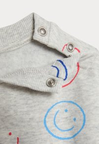 Grauer Sweatshirt mit rundem Ausschnitt und metallischen Druckknöpfen. Verfügt über Designs mit blauen und roten Smiley-Gesichtern. Weiche, Texturierte Innenseite.