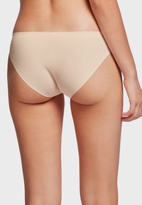 Nude seamless majtki hipster z gładką fakturą i falbaniastymi krawędziami, zaprojektowane z myślą o komforcie i minimalnej widoczności pod odzieżą.
