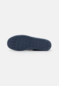 Suola di scarpa in gomma navy con motivi di grip circolari, profilo piatto e leggera indentazione per una maggiore flessibilità. Contrassegnata con la taglia 42.