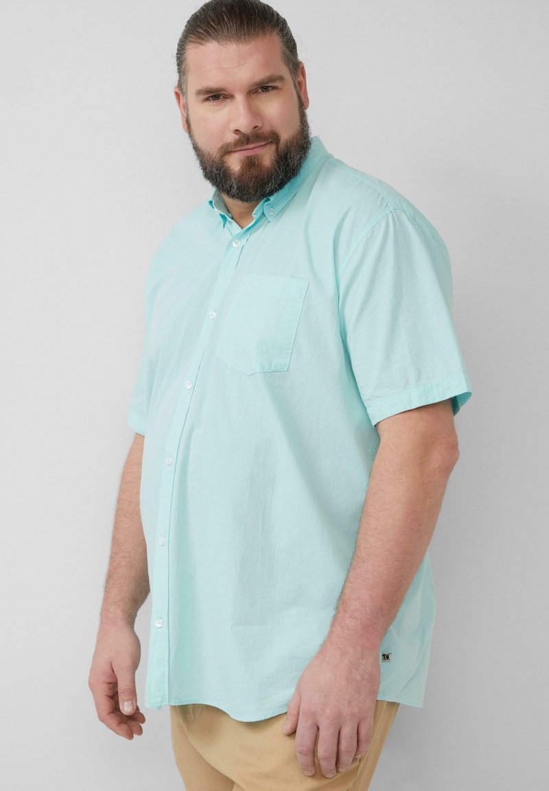 Licht turquoise korte mouwen overhemd met knopen, een borstzak en subtiele textuur, met een ronde zoom en een klein logo aan de zijkant.