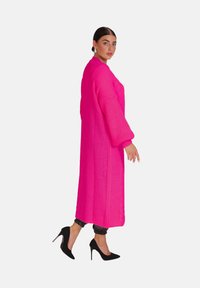 Lång, livfull rosa stickad cardigan med breda, texturerade ärmar och rak skärning. Har kabelstickningsdetalj och sidoflikar.