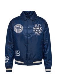 Navy blue satin bomber jacket with embroidered patches, including a logo, number 12, and striped rib-knit cuffs and hem.