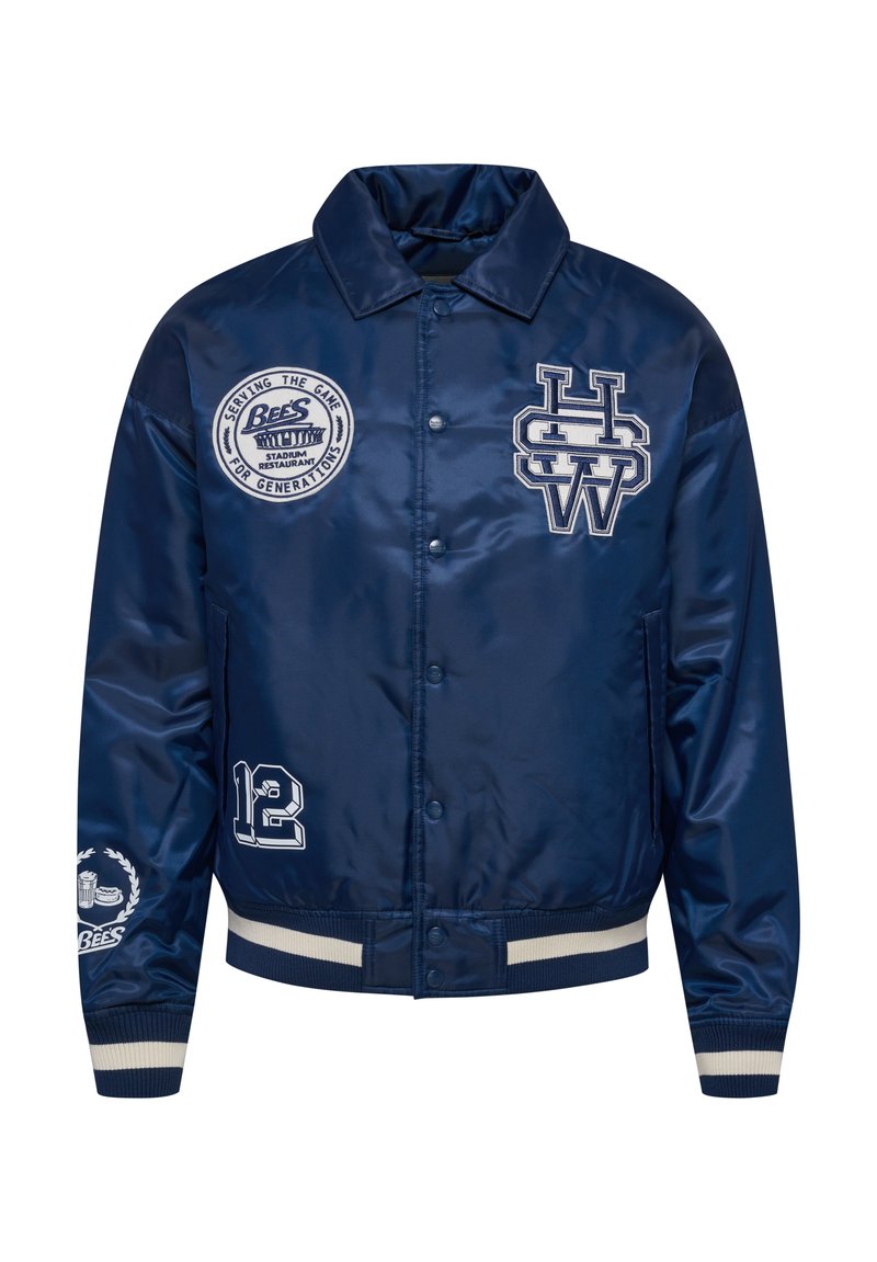 Marineblauwe satijnen bomberjack met geborduurde patches, waaronder een logo, het nummer 12, en gestreepte ribgebreide manchetten en zoom.