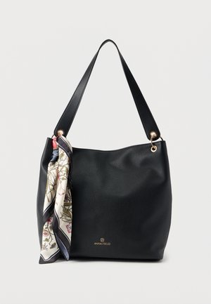 Sac à main en cuir noir texturé avec une seule bandoulière et une écharpe à motif floral nouée d'un côté, marqué Anna Field en lettres dorées.