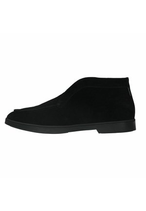 Black suede ankle boots with a smooth texture, rounded toe, and a low black rubber sole; minimalistic design with no visible hardware.