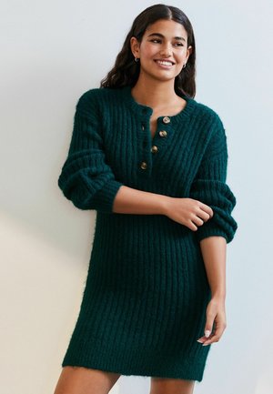 Robe en tricot côtelé verte avec un col rond, une patte de boutonnage et des poignets enroulés. Le tissu semble doux avec une finition texturée.
