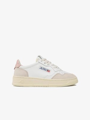 Baskets basses blanches avec des accents en daim beige, semelle crème, lacets et patch logo Autry avec un drapeau américain sur le côté.