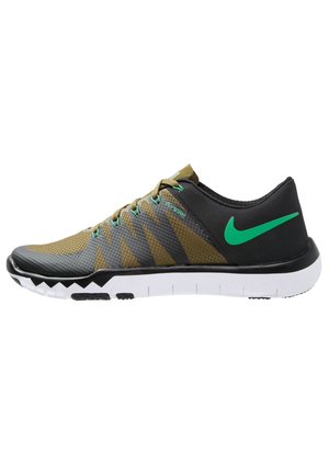 Chaussure de sport à profil bas en vert olive et noir avec un swoosh Nike vert, soutien Flywire et semelle blanche segmentée.