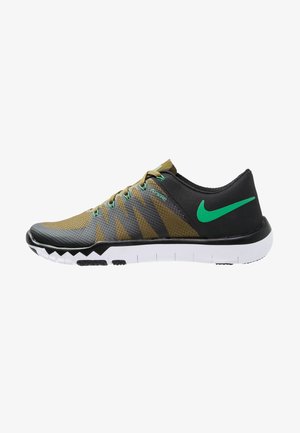 Chaussure de sport à profil bas en vert olive et noir avec un swoosh Nike vert, soutien Flywire et semelle blanche segmentée.