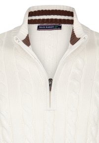 Weißer Strickpullover mit Reißverschluss, mit Kabelmustern und einem braun-weißen gestreiften Kragen. Markenetikett sichtbar.
