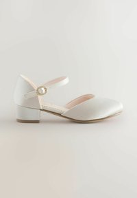 Witte satijnen schoenen met lage hak, gesloten ronde neus en enkelband met een kleine decoratieve gesp.