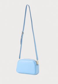 Light blue handbag with a rectangular shape, smooth leather texture, gold hardware, and an adjustable strap. Zippered closure.