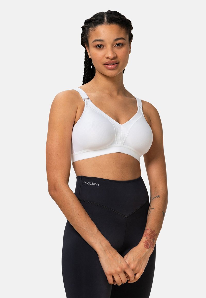 Reggiseno bianco in tessuto liscio ed elastico, con coppe imbottite e spalline regolabili. Abbinato a leggings neri a vita alta con logo.