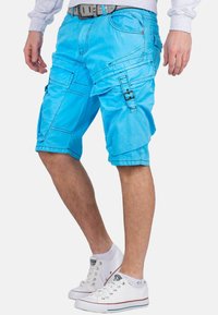 Shorts cargo bleus en tissu léger, dotés de plusieurs poches, d'une fermeture éclair et de détails de couture contrastés.