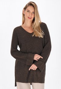 Pulover tricotat texturat de culoare maro, cu decolteu în V, mâneci lungi și fante laterale. Materialul pare moale și călduros, având o croială lejeră.