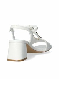 Sandali bianchi con tacco a blocco spesso, punta aperta e cinturini incrociati. Materiale sintetico liscio con una leggera lucentezza, caratterizzati da un design minimale.
