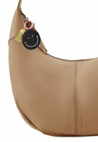 Braune Leder-Hobo-Tasche mit glatter Textur, geschwungener Form und Reißverschlussverschluss. Sie verfügt über einen schwarzen Smiley-Anhänger mit einer Quastenakzent.