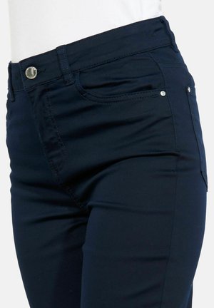 Suurplaan tumelubade, esitaskute, vööaugude ja hõbedase nööpklambriga pükstest valgel taustal.